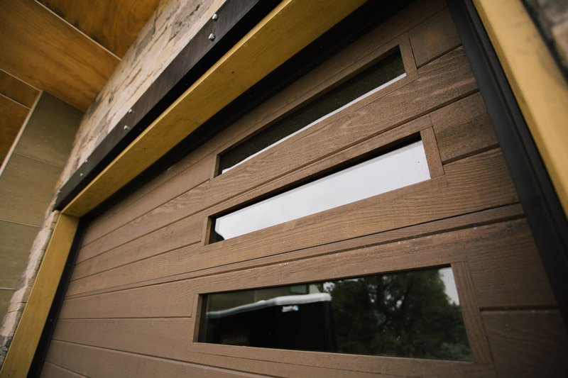 Close up of custom wood garage door with vertical windows 