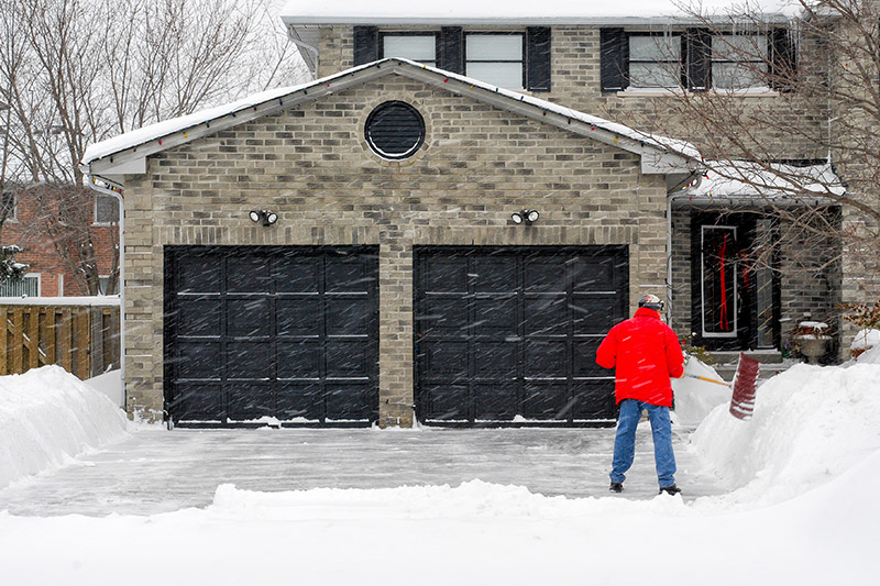 garage door service, man shoveling in front of garage